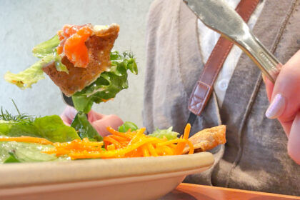 仙台朝市の「Louver」で、サーモンとサワークリームのガレットをフォークで一口食べる様子。シズル感のあるリアルなカット。