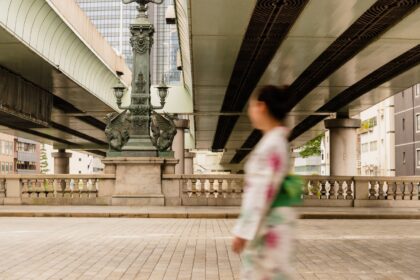 浴衣を着た女性が、日本橋を歩いて渡っている様子